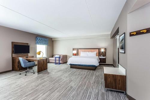基特里Hampton Inn & Suites Kittery的配有一张床和一张书桌的酒店客房