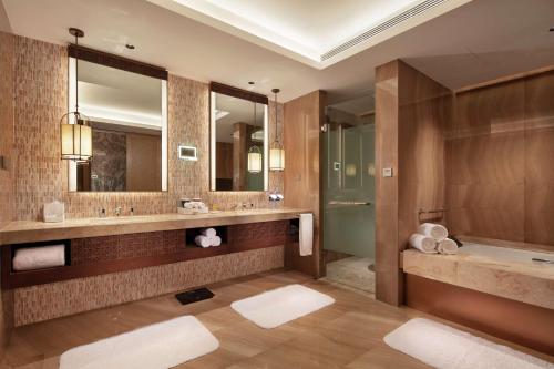 惠东惠东富力希尔顿逸林度假酒店的浴室配有2个盥洗盆、浴缸和镜子
