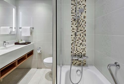 哈博罗内Hilton Garden Inn Gaborone, Botswana的带淋浴、卫生间和盥洗盆的浴室