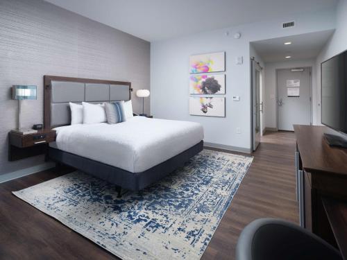 迪凯特Hampton Inn & Suites Atlanta Decatur/Emory的酒店客房配有一张床、一张书桌和一台电视。