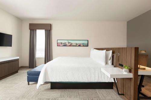 西塔科Hilton Garden Inn Seattle Airport的配有一张床和一张书桌的酒店客房