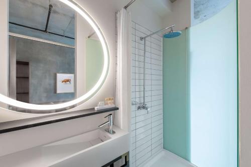 欧文NYLO Las Colinas Hotel, Tapestry Collection by Hilton的一间带大镜子和淋浴的浴室