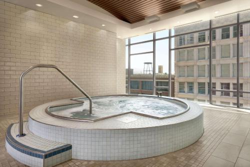 芝加哥Homewood Suites By Hilton Chicago Downtown South Loop的带大窗户的客房内的热水浴池
