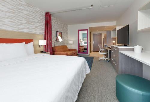 亚基马Home2 Suites By Hilton Yakima Airport的酒店客房设有一张大床和一张书桌。