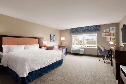 大洋城Hampton Inn & Suites Ocean City West的酒店客房设有一张大床和一张书桌。