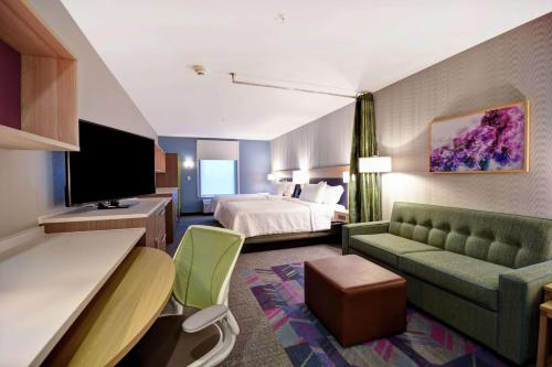 乔治城Home2 Suites By Hilton Georgetown的酒店客房,配有床和沙发