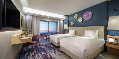 阿菲永Doubletree By Hilton Afyonkarahisar的酒店客房设有两张床和电视。