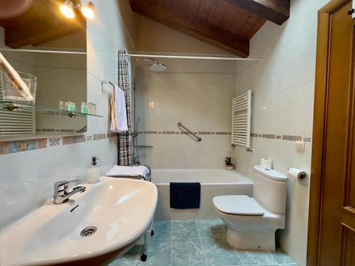 贝纳斯克拉尔达纳民宿的浴室配有盥洗盆、卫生间和浴缸。