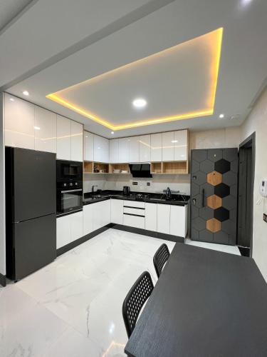 胡塞马Royal Rif Al Hoceima的厨房配有白色橱柜和桌椅