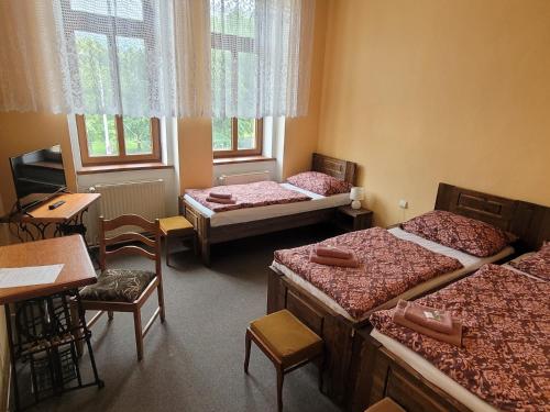 俄斯特拉发马科斯西梅克酒店的带三张床和桌椅的房间