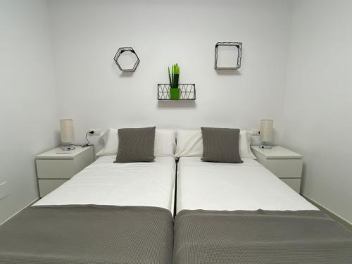 帕拉弗鲁赫尔APARTAMENTS L’ARC的白色墙壁客房的两张床