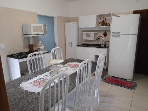波梅罗迪Casa Oma Loni的厨房配有桌椅和冰箱。
