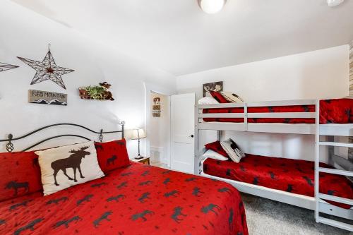 加登城Moose Haven的一间卧室配有两张双层床和一张红色的床罩