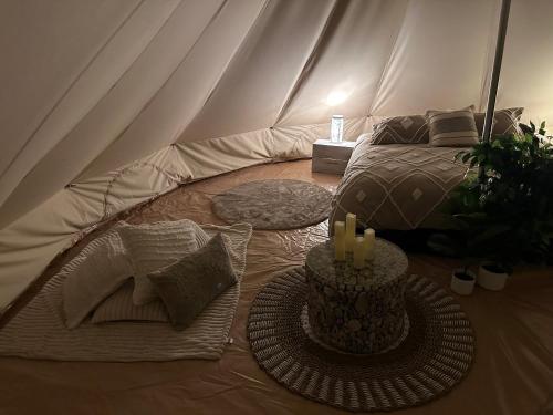 NoonamahNoonamah Tourist Park的帐篷配有一张床和一张带蜡烛的桌子