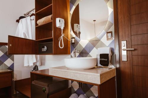 德尔奇亚港Nuxká Hotel by Heaven的一间带水槽和镜子的浴室