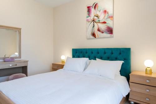 罗德镇namaste的一间卧室配有一张白色大床和蓝色床头板