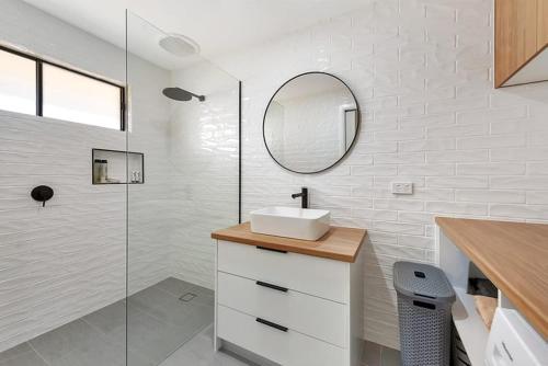 穆尔瓦拉Lakeside Apartment on Pool Avenue的白色的浴室设有水槽和镜子