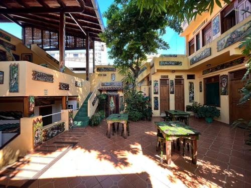 马瑙斯Hostel Manaus的庭院内有长椅和桌子的建筑