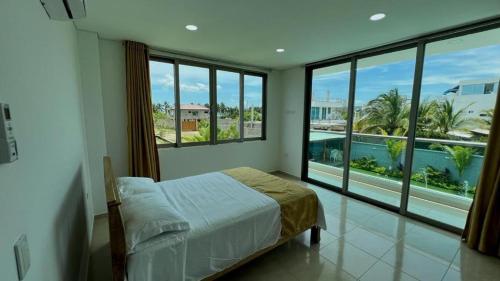 TubaráPalm Beach Resort的一间卧室设有一张床和一个大窗户