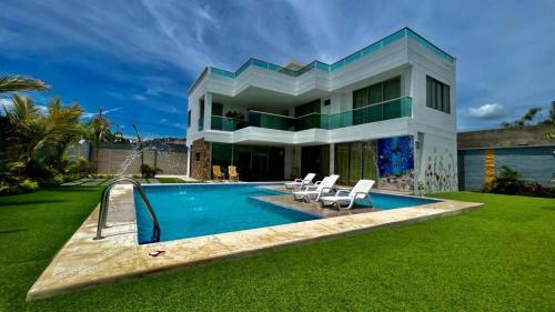 TubaráPalm Beach Resort的一座房子前面设有游泳池