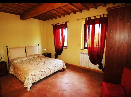 OrentanoLa Ginestra的一间卧室配有床和两个带红色窗帘的窗户。