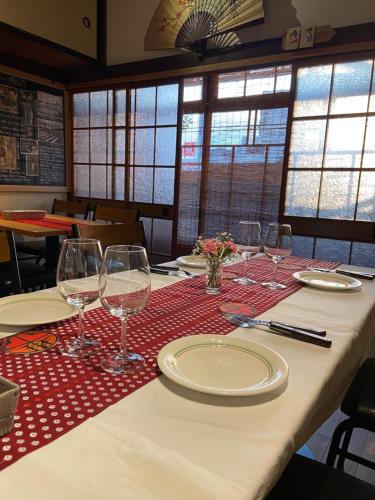 桐生市Okiya Guest House & Tapas Bar的桌子上带玻璃杯和盘子的桌子
