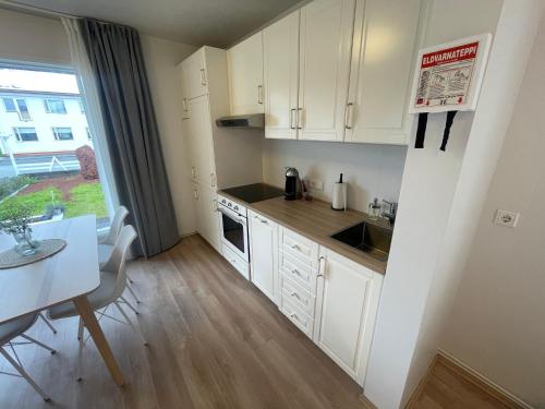 惠拉盖尔济Cosy Studio Apartment的小厨房配有白色橱柜和桌子