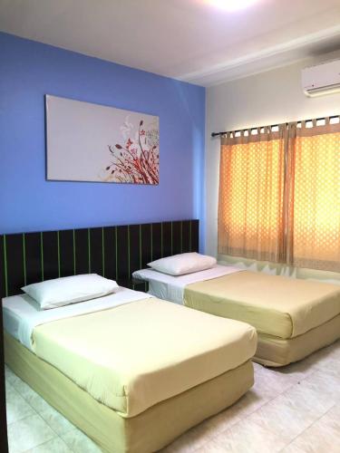 来兴府Suansin Garden Hotel โรงแรมสวนสินการ์เด้น的蓝色墙壁客房的两张床