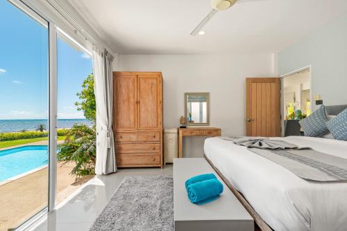 拉迈Beachfront Villa Baan Rim Haad 3BR的一间卧室配有一张床,享有海景
