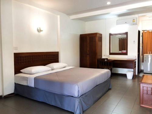 来兴府Suansin Garden Hotel โรงแรมสวนสินการ์เด้น的一间卧室配有一张床、一个水槽和一张书桌