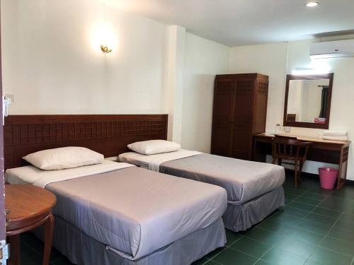 来兴府Suansin Garden Hotel โรงแรมสวนสินการ์เด้น的酒店客房设有两张床、一张桌子和镜子