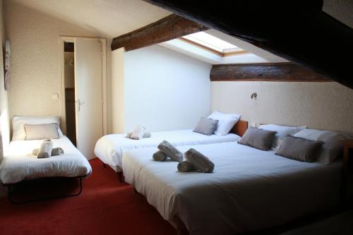 Vergèze西番莲酒店的一间设有两张床的房间,上面有泰迪熊