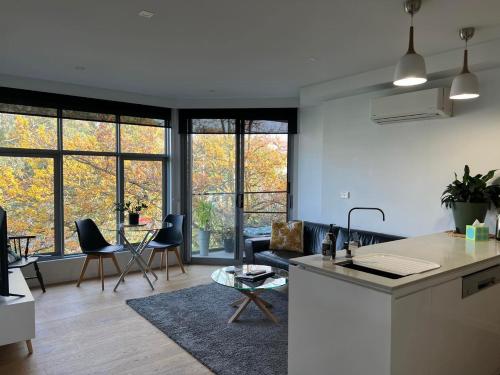 墨尔本Centrepoint Units Heidelberg的厨房以及带沙发和桌子的客厅。