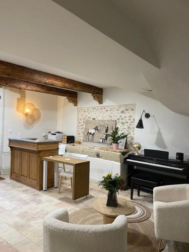 Vergèze西番莲酒店的客厅配有钢琴和桌子