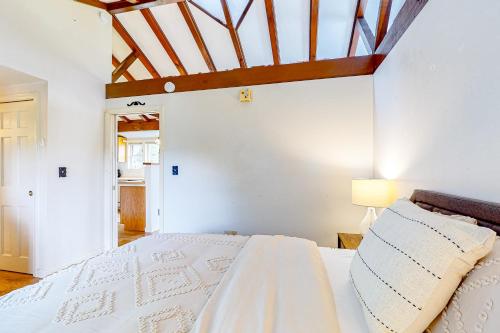 West RutlandThe Carriage House at The Garden Estate的卧室配有白色床和木制天花板