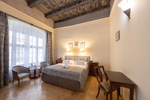 布拉格Hotel Elite Prague的卧室配有一张床和一张桌子及椅子