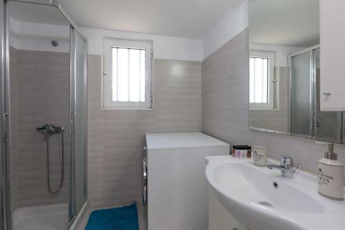 法里拉基Angelana Beach Villa的白色的浴室设有水槽和淋浴。