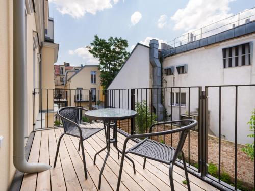 维也纳MySchönbrunn Apartments的阳台的天井配有2把椅子和1张桌子