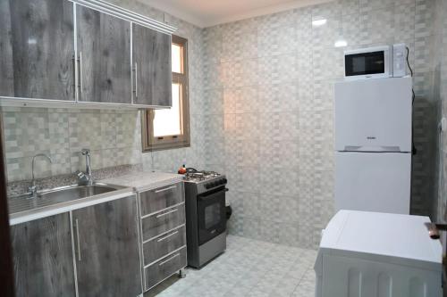 科威特De Iris Regency Fahaheel的一间带水槽和冰箱的小厨房