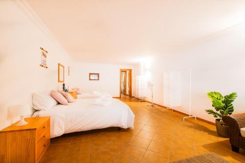 阿尔布费拉Villa Arrifes的白色卧室配有床和桌子