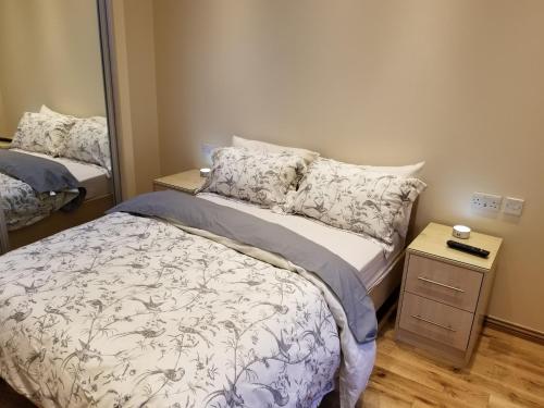 WansteadLondon Luxury Apartment 4 Bedroom Sleeps 12 people with 4 Bathrooms 1 Min walk from Station的一间小卧室,配有一张床和镜子