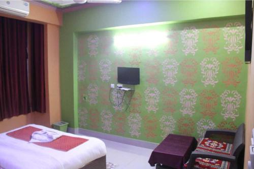 珀勒德布尔The Hotel Raj Palace的一间卧室设有一张床和绿色的墙壁