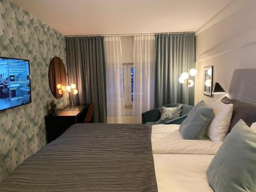 法尔雪平Hotell Syfabriken的酒店客房设有一张大床和一台电视。