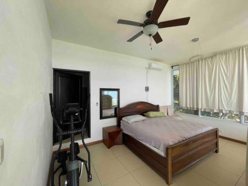 埃尔莱马特Villa Florita Beach House的一间卧室配有一张带吊扇的床和一台电视。