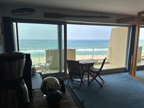 拉卡诺OCEAN VIEW的配有桌椅并享有海滩景色的客房