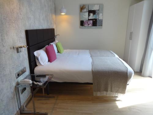 巴塞罗那略雷特兰布拉酒店的一间卧室配有一张带色彩缤纷枕头的大床