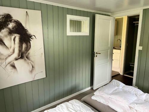 LusterDalsøren Camping og hytter的一间卧室设有绿色的墙壁、一张床和一张图片