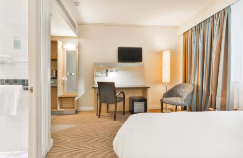 开普敦开普敦市中心快捷假日酒店的酒店客房带一张床、一张桌子和椅子
