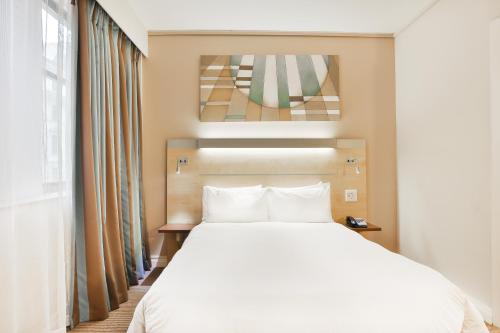 开普敦开普敦市中心快捷假日酒店的卧室设有一张白色大床和一扇窗户。