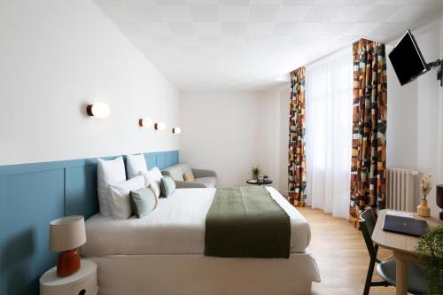 昂热Hôtel Suzane的卧室配有一张白色大床和一张书桌